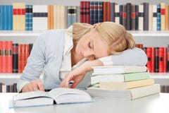 Vrouwelijke studentenslaap in een bibliotheek stock afbeelding Vrouwelijke studentenslaap in een bibliotheek stock afbeelding