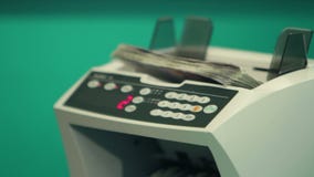 Vrouwenbankier die geld leren te tellen met het tellen van machine stock footage Vrouwenbankier die geld leren te tellen met het tellen van machine stock footage