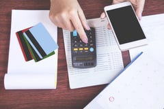 Vrouwenhand die slimme telefoon houden die haar maandelijkse uitgaven met creditcard berekenen, die rekeningsboek, het concept FO royalty-vrije stock foto Vrouwenhand die slimme telefoon houden die haar maandelijkse uitgaven met creditcard berekenen, die rekeningsboek, het concept FO royalty-vrije stock foto