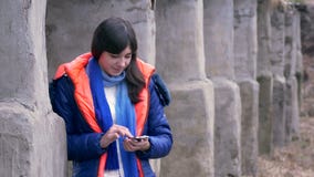 Vrouwenmeisje die een smartphone in jasjesjaal houden stock videobeelden Vrouwenmeisje die een smartphone in jasjesjaal houden stock videobeelden