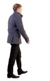 Vue arrière d'homme bel allant d'affaires dans le manteau. photos stock Vue arrière d'homme bel allant d'affaires dans le manteau. photos stock
