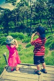 Vue arrière des enfants asiatiques détendant dehors pendant la journée, TR image stock Vue arrière des enfants asiatiques détendant dehors pendant la journée, TR image stock