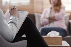 Vue arrière des notes d'écriture de psychothérapeute, évaluant le ` patient s photo libre de droits Vue arrière des notes d'écriture de psychothérapeute, évaluant le ` patient s photo libre de droits
