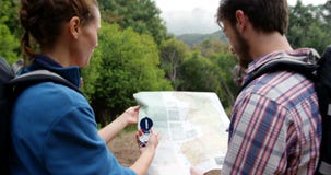 Vue arrière des randonneurs regardant une carte avec une boussole Vue arrière des randonneurs regardant une carte avec une boussole