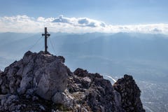 Vue au-dessus d'une crête de montagne avec une croix de sommet vers le bas à l'Innvalley et à Innsbruck en Autriche en automne co image libre de droits Vue au-dessus d'une crête de montagne avec une croix de sommet vers le bas à l'Innvalley et à Innsbruck en Autriche en automne co image libre de droits