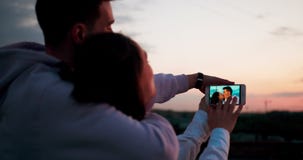 Vue au-dessus d'épaule affectueuse de couples Ils regardent les photos où ils embrassent banque de vidéos Vue au-dessus d'épaule affectueuse de couples Ils regardent les photos où ils embrassent banque de vidéos