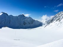 Vue au glacier de Mensu du passage de montagne de Delone Grimpeurs de montagne marchant ? travers la vall?e de neige R?gion de mo images libres de droits Vue au glacier de Mensu du passage de montagne de Delone Grimpeurs de montagne marchant ? travers la vall?e de neige R?gion de mo images libres de droits