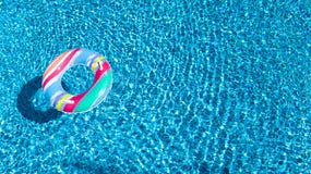 Vue aérienne de jouet gonflable coloré de beignet d'anneau dans l'eau de piscine d'en haut, concept de vacances de famille images libres de droits Vue aérienne de jouet gonflable coloré de beignet d'anneau dans l'eau de piscine d'en haut, concept de vacances de famille images libres de droits