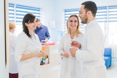 Vue courbe de trois médecins dans des manteaux blancs ayant la conversation au hall d'hôpital photographie stock libre de droits Vue courbe de trois médecins dans des manteaux blancs ayant la conversation au hall d'hôpital photographie stock libre de droits