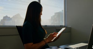 Vue de c?t? de la jeune femme d'affaires caucasienne travaillant au comprim? num?rique dans un bureau moderne 4k banque de vidéos Vue de c?t? de la jeune femme d'affaires caucasienne travaillant au comprim? num?rique dans un bureau moderne 4k banque de vidéos