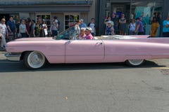 Vue de côté de Cadillac rose sur la rue anglaise occupée pendant le festival circulant en voiture images libres de droits Vue de côté de Cadillac rose sur la rue anglaise occupée pendant le festival circulant en voiture images libres de droits