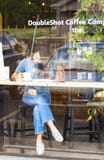 Vue de fille dans la fenêtre de café travaillant aux écritures avec le téléphone étendant le tir voisin par des réflexions d'exté image libre de droits Vue de fille dans la fenêtre de café travaillant aux écritures avec le téléphone étendant le tir voisin par des réflexions d'exté image libre de droits