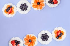 Vue de meringue avec des myrtilles, des fraises et des mandarines sur un fond de lavande Vue sup?rieure photographie stock libre de droits Vue de meringue avec des myrtilles, des fraises et des mandarines sur un fond de lavande Vue sup?rieure photographie stock libre de droits
