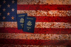 Vue de Pverhead de deux passeports des USA sur un fond rustique de drapeau américain images libres de droits Vue de Pverhead de deux passeports des USA sur un fond rustique de drapeau américain images libres de droits
