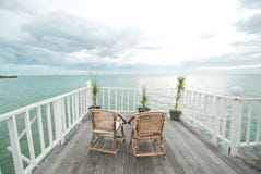 Vue des terrasses blanches avec les chaises en bois photo stock Vue des terrasses blanches avec les chaises en bois photo stock