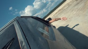 Vue en gros plan du côté de la voiture russe noire se déplaçant sur la surface arénacée avec l'homme regardant hors de la voiture clips vidéos Vue en gros plan du côté de la voiture russe noire se déplaçant sur la surface arénacée avec l'homme regardant hors de la voiture clips vidéos
