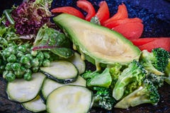 Vue haute ?troite sur la salade verte avec l'avocat dans servi dans le plat texturis? noir sur le fond fonc? Nourriture plate de image libre de droits Vue haute ?troite sur la salade verte avec l'avocat dans servi dans le plat texturis? noir sur le fond fonc? Nourriture plate de image libre de droits
