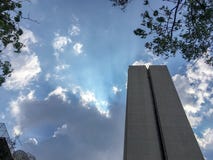 Vue inférieure de l'immeuble de bureaux sur le ciel bleu de nuages avec le fond de lumière du soleil images stock Vue inférieure de l'immeuble de bureaux sur le ciel bleu de nuages avec le fond de lumière du soleil images stock
