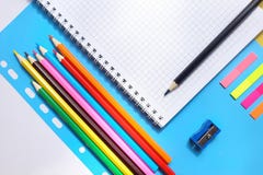 Vue supérieure au-dessus de carnets, crayons multicolores, affûteuse sur un fond bleu De nouveau au concept d'école photos stock Vue supérieure au-dessus de carnets, crayons multicolores, affûteuse sur un fond bleu De nouveau au concept d'école photos stock