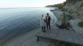 Vue supérieure d'un jeune couple embrassant tendrement à la rivière Une position attrayante de couples sur une plate-forme en boi banque de vidéos Vue supérieure d'un jeune couple embrassant tendrement à la rivière Une position attrayante de couples sur une plate-forme en boi banque de vidéos