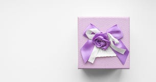 Vue supérieure de boîte-cadeau pourpre avec l'arc de ruban de satin sur le fond blanc photographie stock libre de droits Vue supérieure de boîte-cadeau pourpre avec l'arc de ruban de satin sur le fond blanc photographie stock libre de droits
