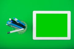 Vue supérieure de plan de travail comprimé blanc avec un écran vide et un organisateur avec des stylos images stock Vue supérieure de plan de travail comprimé blanc avec un écran vide et un organisateur avec des stylos images stock