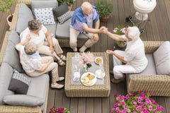 Vue supérieure sur les personnes supérieures parlant au cours de la réunion sur la terrasse image stock Vue supérieure sur les personnes supérieures parlant au cours de la réunion sur la terrasse image stock