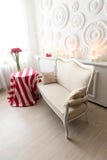 Vue sur une salle confortable avec un sofa confortable et une table brillamment étendue photos stock Vue sur une salle confortable avec un sofa confortable et une table brillamment étendue photos stock