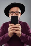 Vuxen maninnehavsmartphone framme av hans framsida arkivbilder Vuxen maninnehavsmartphone framme av hans framsida arkivbilder