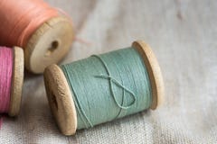 Vintage wooden thread spools on linen cloth, pastel colors, closeup, styled image Stock Images Vintage wooden thread spools on linen cloth, pastel colors, closeup, styled image Stock Images