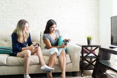 Vänner som konkurrerar, medan spela videogamen hemma royaltyfri foto Vänner som konkurrerar, medan spela videogamen hemma royaltyfri foto