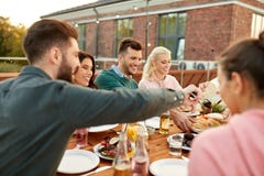 Vänner som äter hamburgare på matställepartiet på tak fotografering för bildbyråer Vänner som äter hamburgare på matställepartiet på tak fotografering för bildbyråer