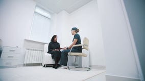 Vårda att fråga häftet av en patient på ett sjukhusmottagande lager videofilmer Vårda att fråga häftet av en patient på ett sjukhusmottagande lager videofilmer