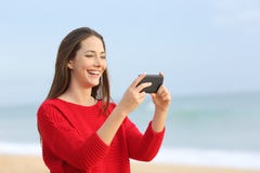 Vídeos de observação de riso da menina no telefone esperto Foto de Stock Vídeos de observação de riso da menina no telefone esperto Foto de Stock