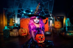 Víspera de Todos los Santos feliz Una pequeña muchacha hermosa en un traje de la bruja celebra con las calabazas imagen de archivo libre de regalías Víspera de Todos los Santos feliz Una pequeña muchacha hermosa en un traje de la bruja celebra con las calabazas imagen de archivo libre de regalías
