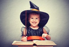 Víspera de Todos los Santos pequeña bruja alegre con el conjur mágico de la vara y del libro fotos de archivo libres de regalías Víspera de Todos los Santos pequeña bruja alegre con el conjur mágico de la vara y del libro fotos de archivo libres de regalías