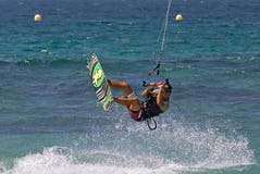 Vôo de Kitesurfer através do ar em uma praia ensolarada foto de stock Vôo de Kitesurfer através do ar em uma praia ensolarada foto de stock