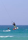 Vôo de Kitesurfer através do ar em uma praia ensolarada fotografia de stock Vôo de Kitesurfer através do ar em uma praia ensolarada fotografia de stock