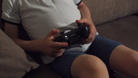W górę chłopiec trzyma joystick i bawić się gra wideo w domu troszkę zbiory W górę chłopiec trzyma joystick i bawić się gra wideo w domu troszkę zbiory