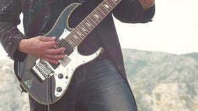 W górę mężczyzny bawić się basową gitarę zapas W górę gitarzysty bawić się bas na tle góry zbiory W górę mężczyzny bawić się basową gitarę zapas W górę gitarzysty bawić się bas na tle góry zbiory