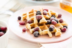 Waffles belgas com mel e as bagas congeladas fotografia de stock royalty free Waffles belgas com mel e as bagas congeladas fotografia de stock royalty free