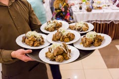 Waiter holding a plate with meat skewers. Waiter serving dishes during the ceremony royalty free stock images Waiter holding a plate with meat skewers. Waiter serving dishes during the ceremony royalty free stock images