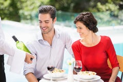 Waiter showing wine bottle to couple Stock Images Waiter showing wine bottle to couple Stock Images