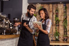 Waitress using a tablet computer and waiter with coffee machine stock photography Waitress using a tablet computer and waiter with coffee machine stock photography