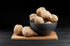 Walnut and walnut kernels on the plate on rustic wooden black background. Stock Photography Walnut and walnut kernels on the plate on rustic wooden black background. Stock Photography