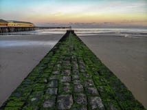 Walton sur le coucher du soleil de brise-lames de pilier de naze photo stock Walton sur le coucher du soleil de brise-lames de pilier de naze photo stock