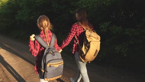 Wandererm?dchen M?dchen mit Rucks?cken sind auf der Landstra?e in der Sonne Konzept von Sporttourismus und -reise Kinder stock footage Wandererm?dchen M?dchen mit Rucks?cken sind auf der Landstra?e in der Sonne Konzept von Sporttourismus und -reise Kinder stock footage