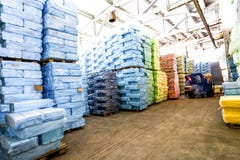 Warehouse con la carretilla elevadora del montar a caballo y las pilas de caja en la fábrica fotos de archivo libres de regalías Warehouse con la carretilla elevadora del montar a caballo y las pilas de caja en la fábrica fotos de archivo libres de regalías