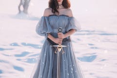 Warlike girl with dark hair in long gray vintage light dress, lady of cold and frost, bare open shoulders and sharp royalty free stock photography Warlike girl with dark hair in long gray vintage light dress, lady of cold and frost, bare open shoulders and sharp royalty free stock photography