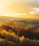 Warm October evening in Transylvania. Magic autumn sunset light over the colored hills